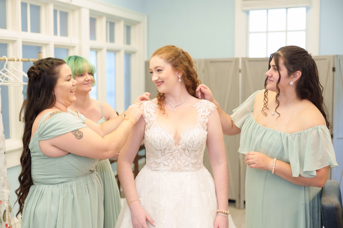 Bridesmaids in sage green help the bride get ready at Pine Lakes Country Club