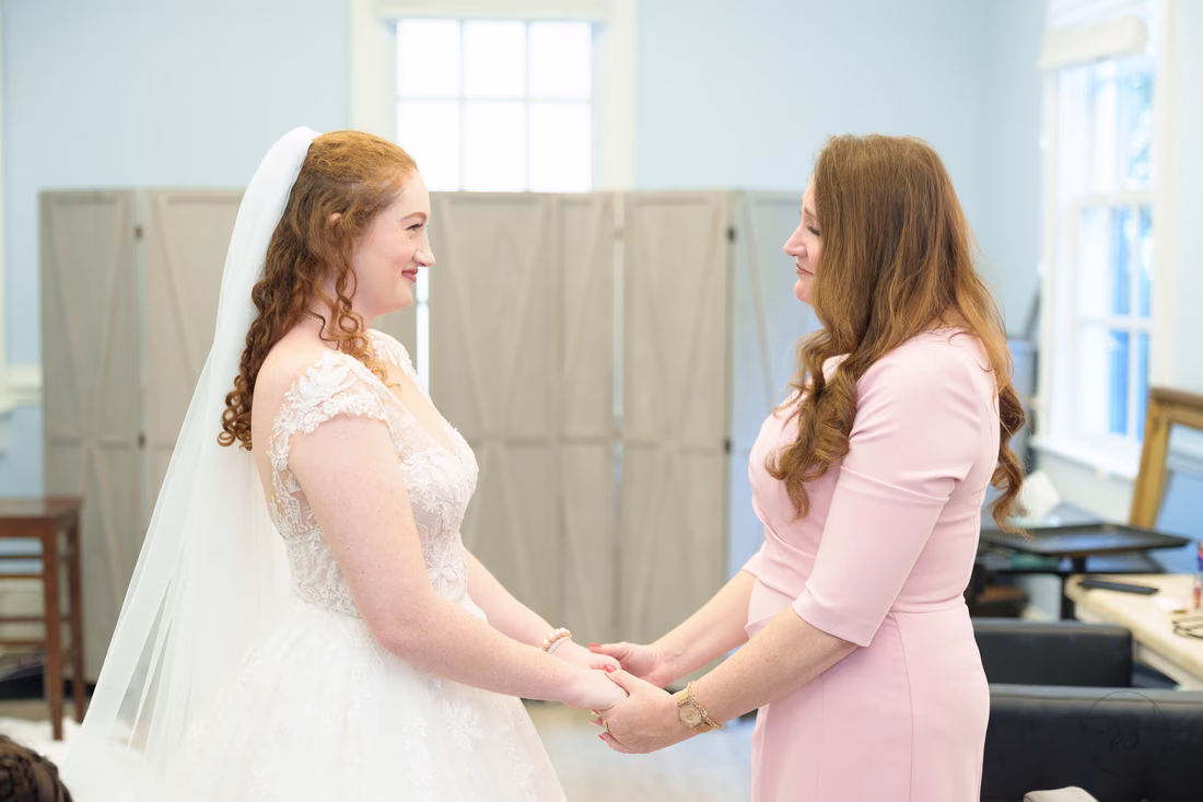 The bride holds hands with a woman in pink before the ceremony at Pine Lakes Country Club