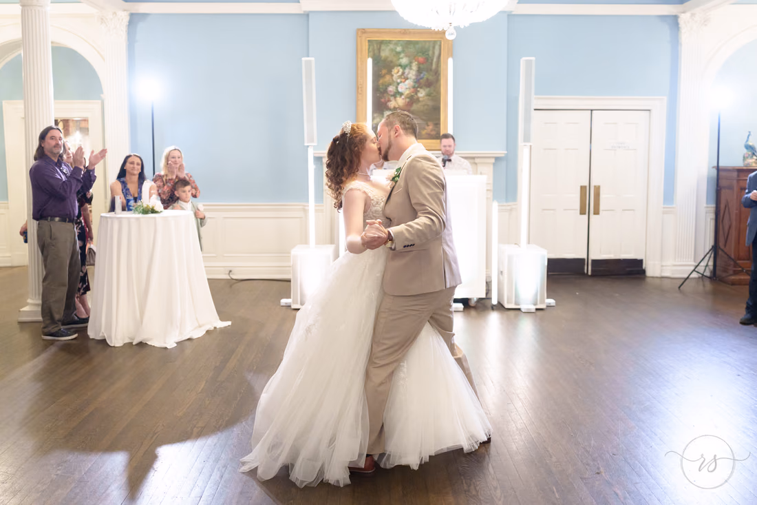 The bride and groom kiss during their first dance at Pine Lakes Country Club
