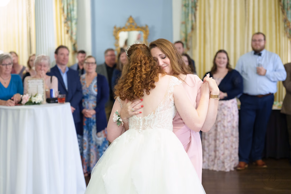 The bride dances with a woman in pink as guests watch at Pine Lakes Country Club
