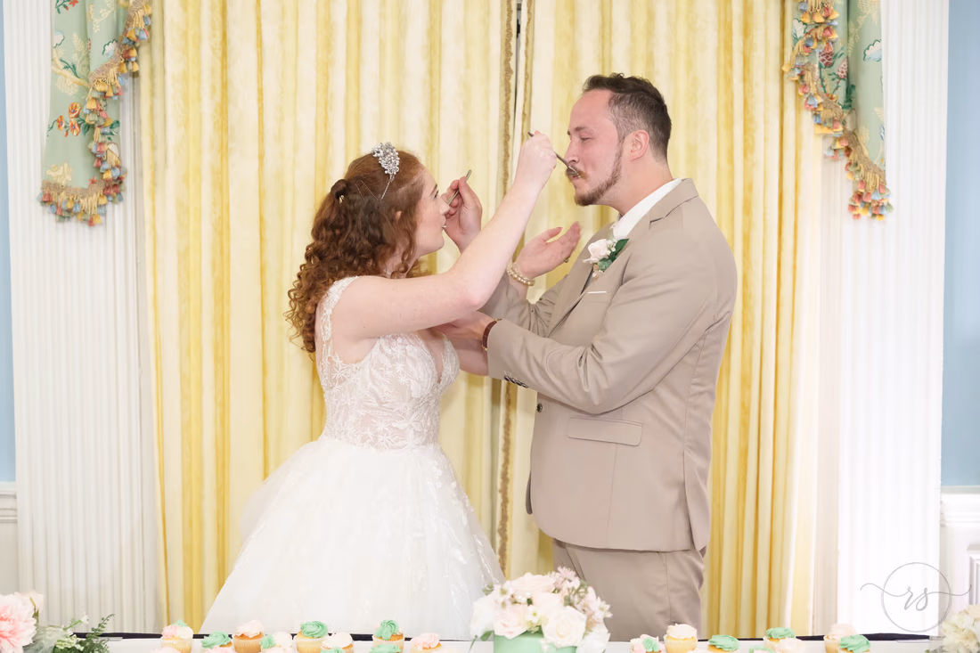 The bride feeds the groom a bite of cake at Pine Lakes Country Club