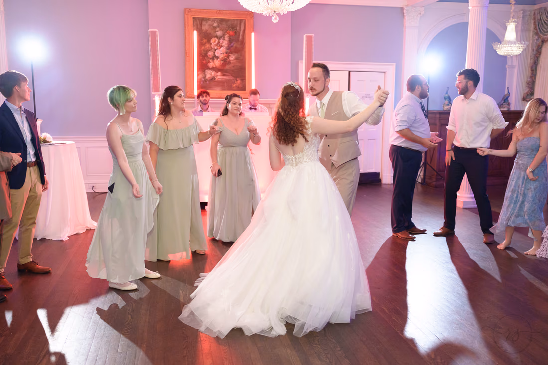 The bride and groom dance in the middle of the crowd at Pine Lakes Country Club