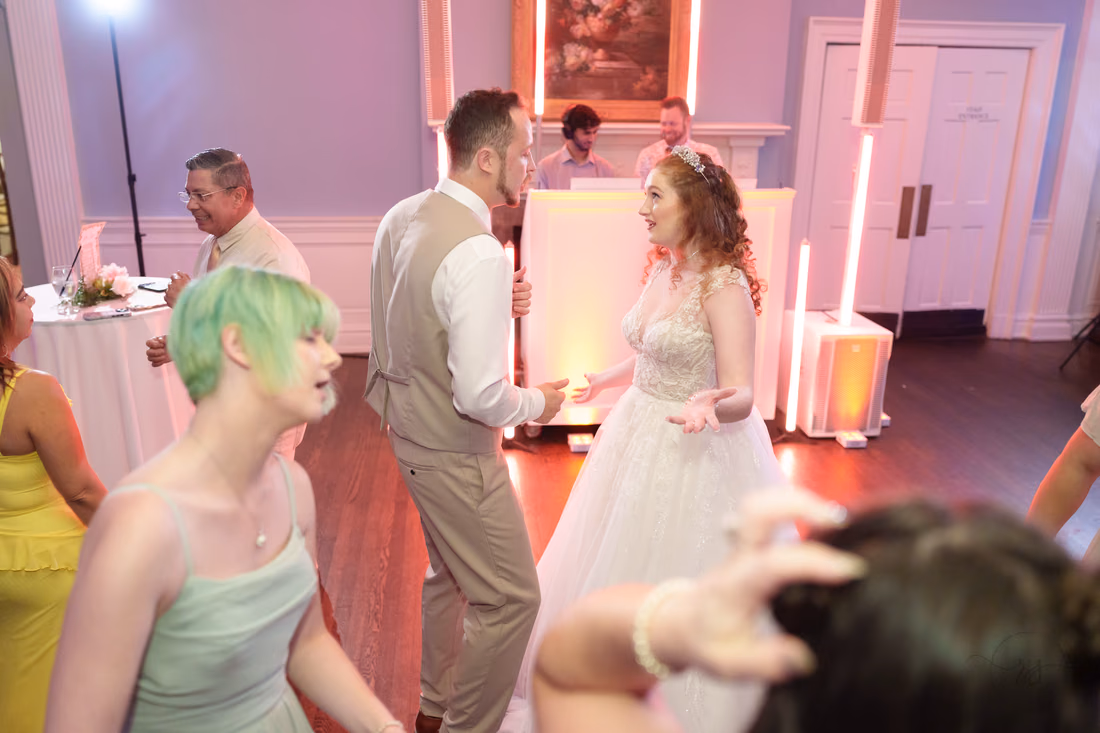 A bridesmaid with green hair dances near the bride and groom at Pine Lakes Country Club