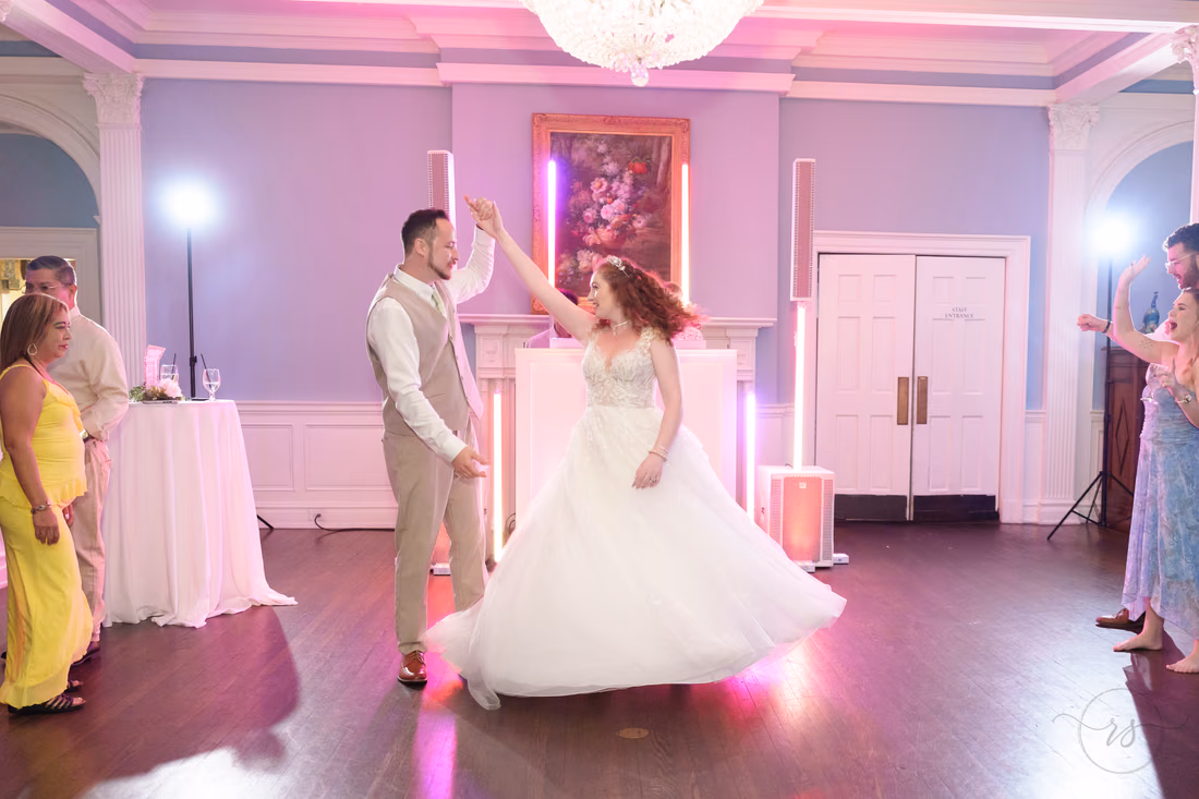 The groom twirls the bride on the dance floor at Pine Lakes Country Club