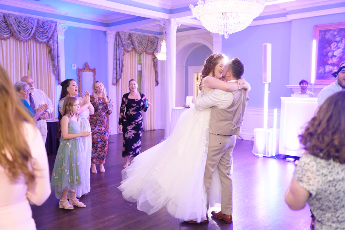 The groom lifts the bride in a hug on the dance floor at Pine Lakes Country Club