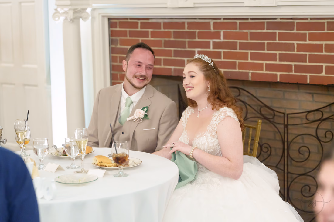 The bride and groom laugh at the sweetheart table at Pine Lakes Country Club
