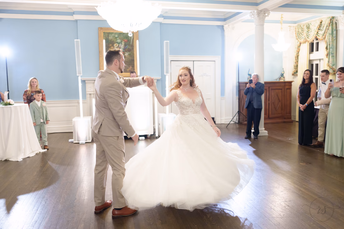 The groom spins the bride during their first dance at Pine Lakes Country Club