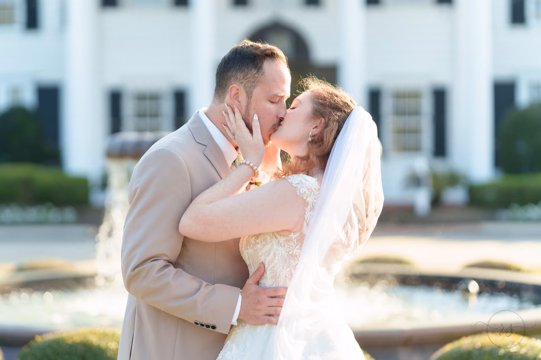 Close-up of the bride and groom kissing by the fountain at Pine Lakes Country Club