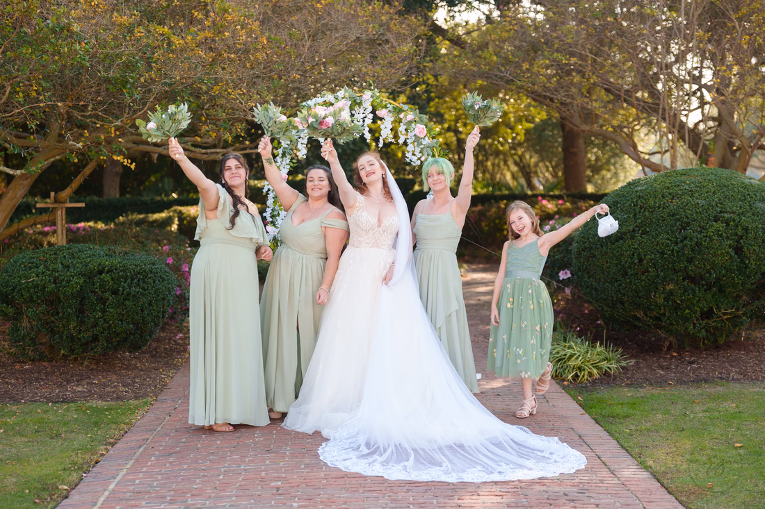 Bridesmaids cheer with their bouquets raised beside the bride at Pine Lakes Country Club