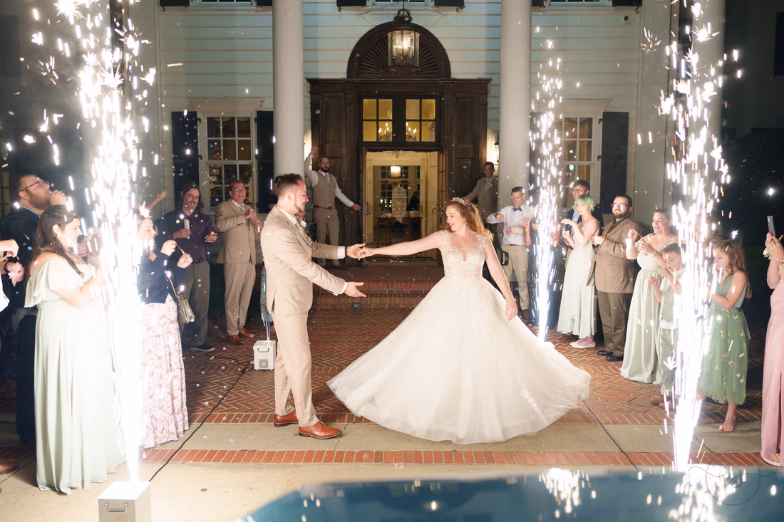 The bride and groom dance between cold sparkler cannons at their exit at Pine Lakes Country Club