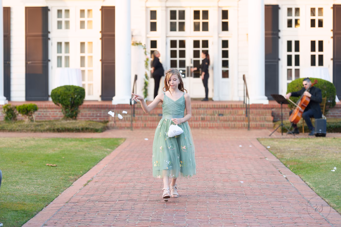 The flower girl tosses petals as she walks down the aisle at Pine Lakes Country Club