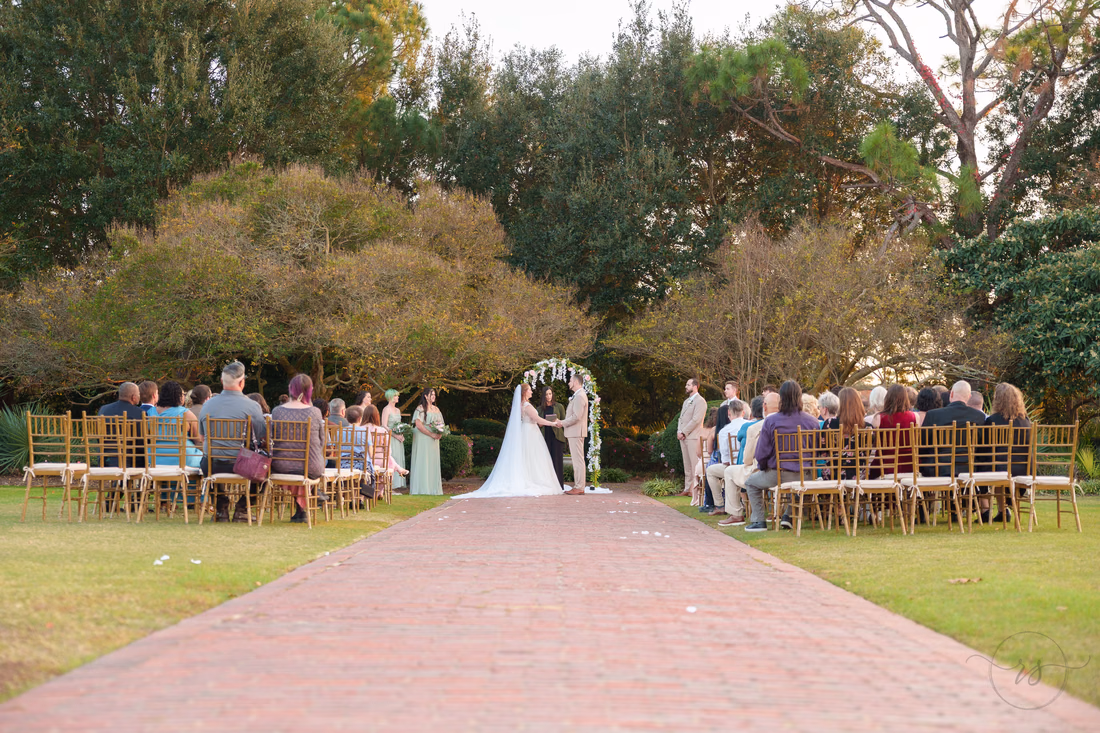 Wide view of the garden ceremony from the end of the brick aisle at Pine Lakes Country Club