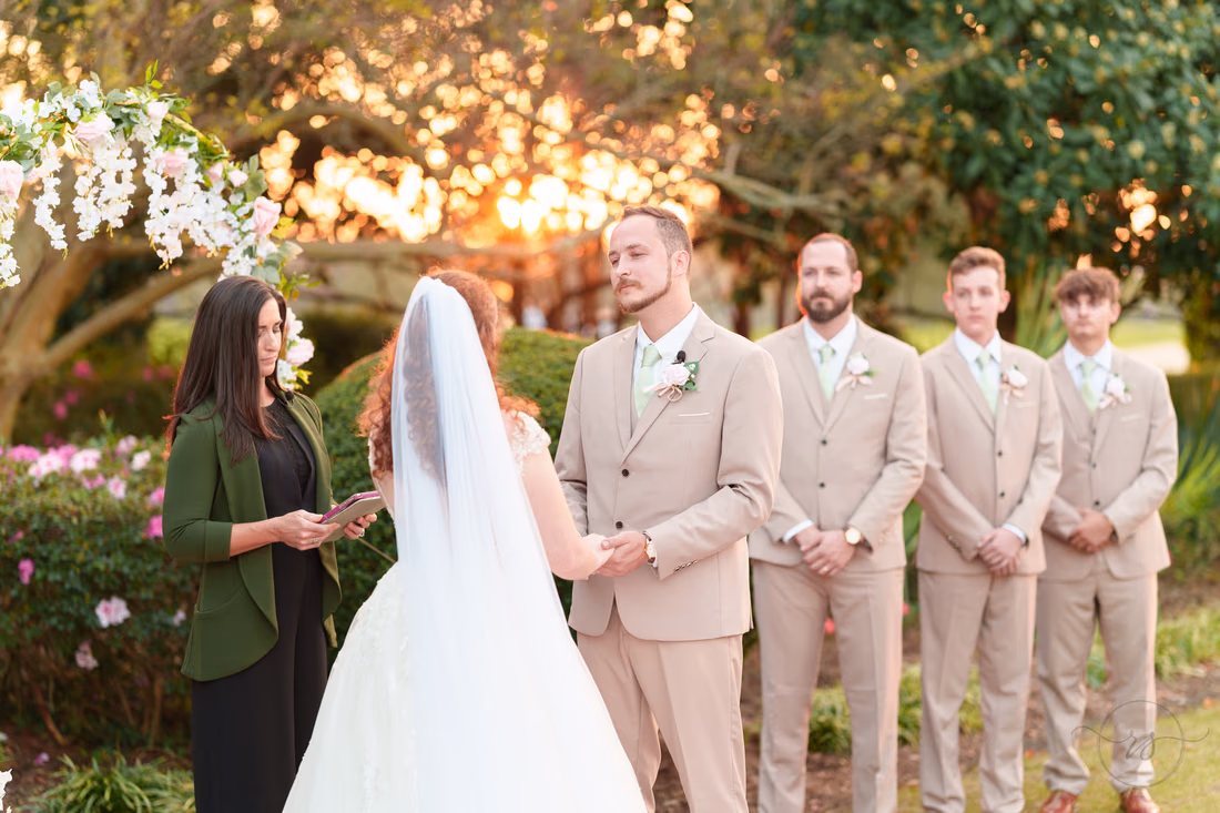 The groom smiles at the bride as the officiant begins at Pine Lakes Country Club