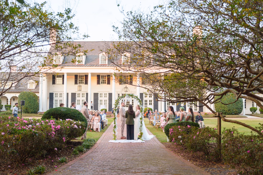 The garden ceremony seen from a distance with the clubhouse behind at Pine Lakes Country Club