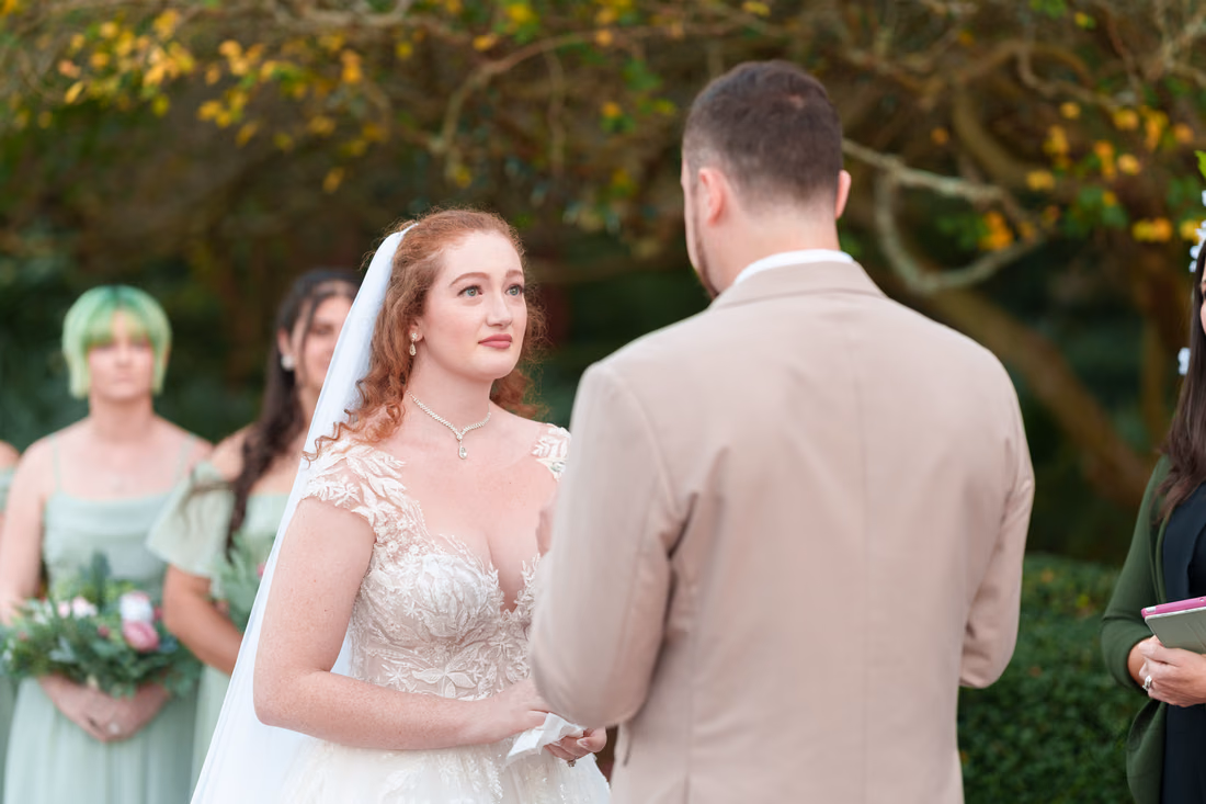 The bride listens to the groom's vows at Pine Lakes Country Club