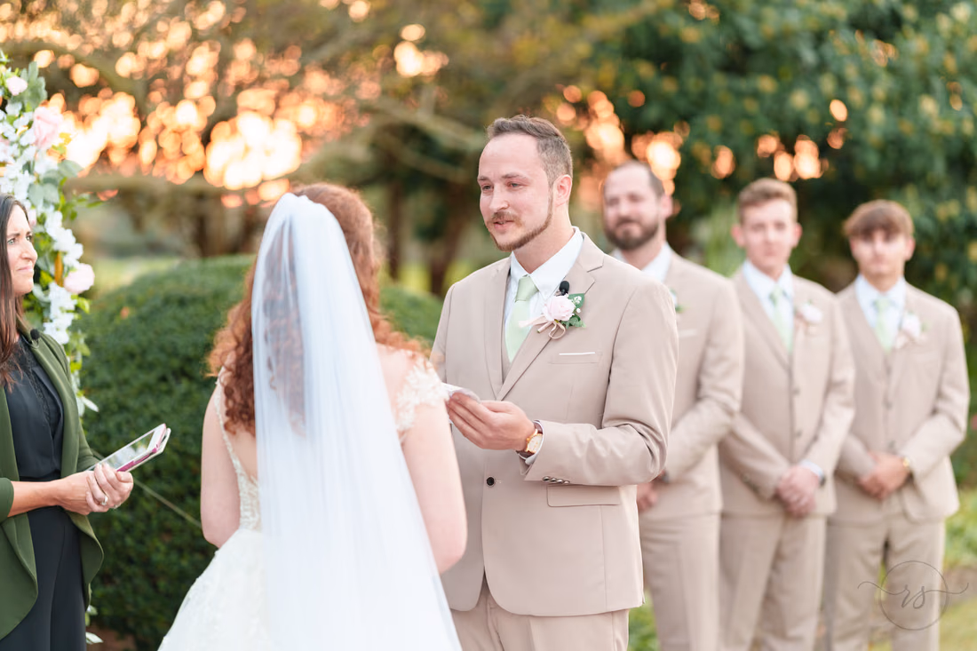 The groom reads his vows with sunlight through the trees at Pine Lakes Country Club