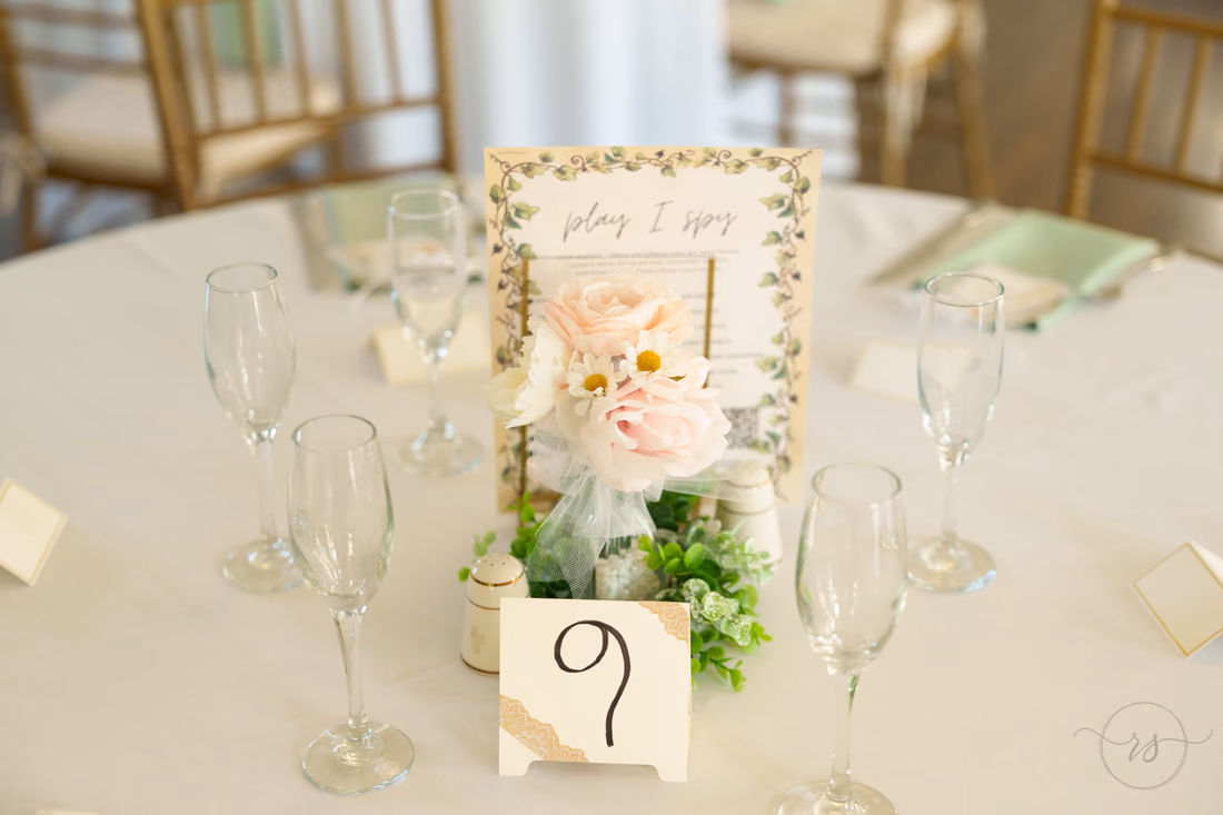 Reception table with champagne flutes, flowers and table number nine at Pine Lakes Country Club