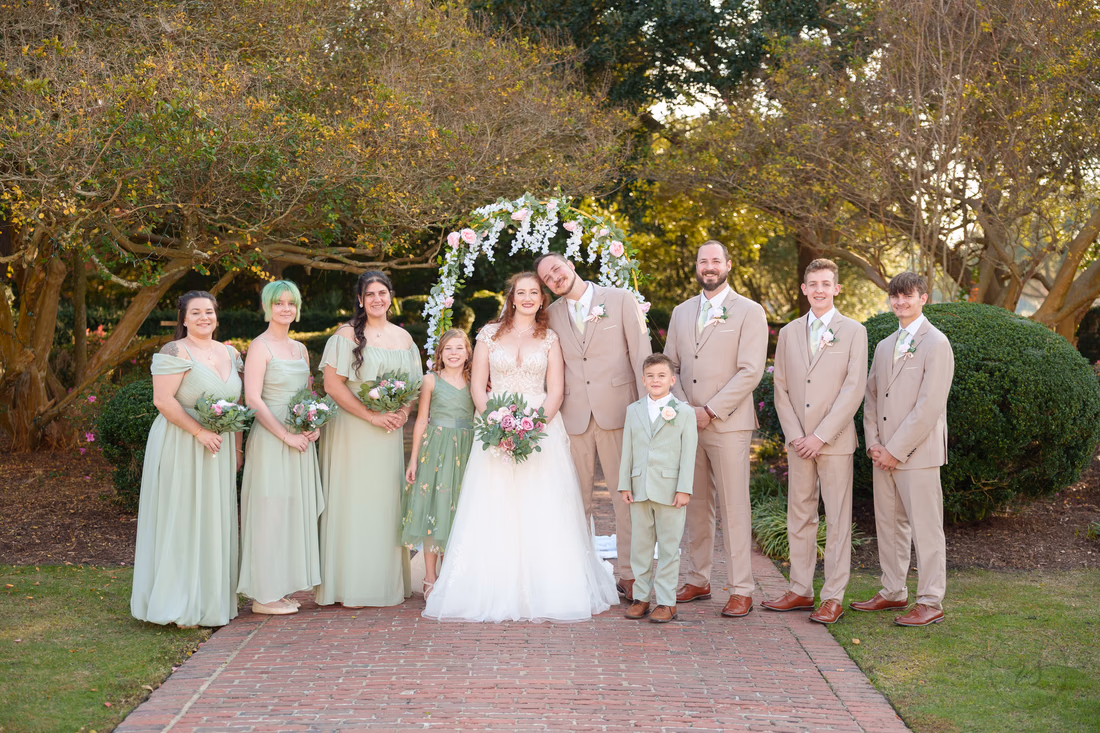 The wedding party with the flower girl and ring bearer on the garden path at Pine Lakes Country Club