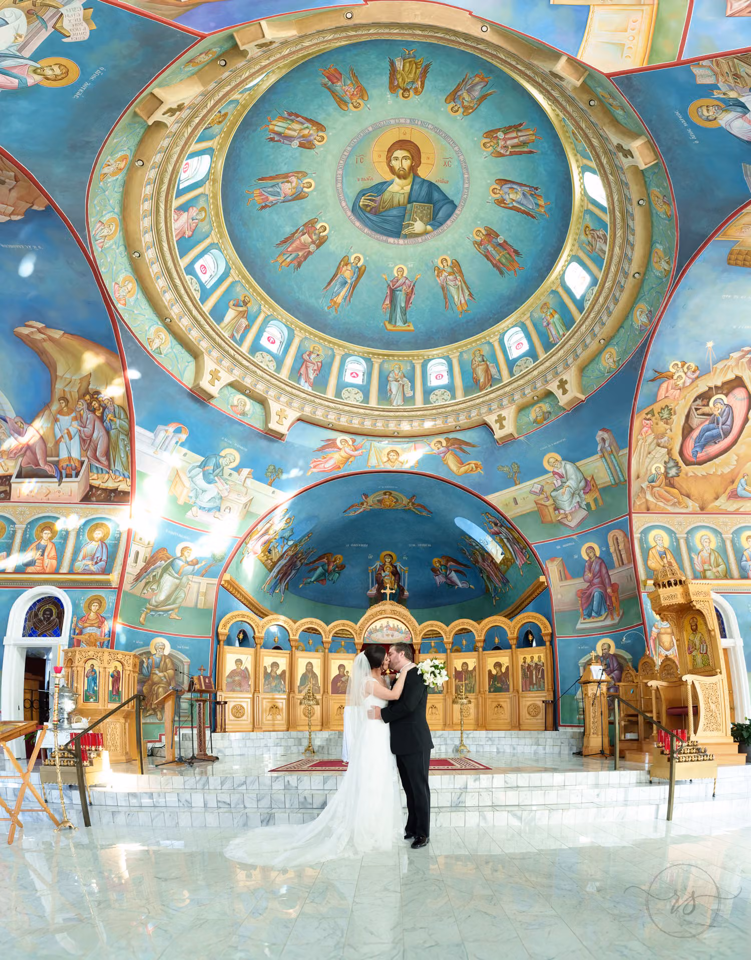 Painted dome and icons inside the church with the bride and groom at the altar at St. John in Myrtle Beach