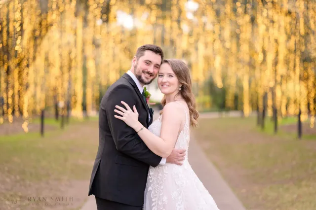 Bride and groom smiling cheek to cheek on the Oak Allee during Night of a Thousand Candles at Brookgreen Gardens