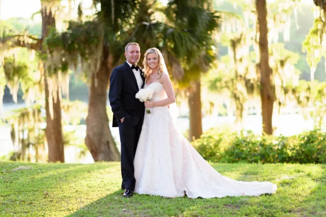 Bride and groom smiling in the late sun under mossy trees at Kimbel's at Wachesaw Plantation