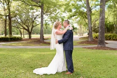 Bride pulling groom in for a kiss in front of the clubhouse - Pawleys Plantation