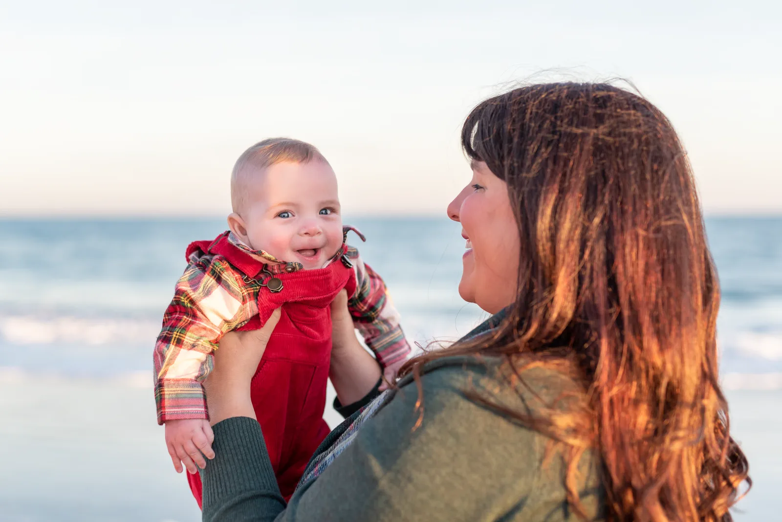 Mom holding baby boy looking into the camera -
