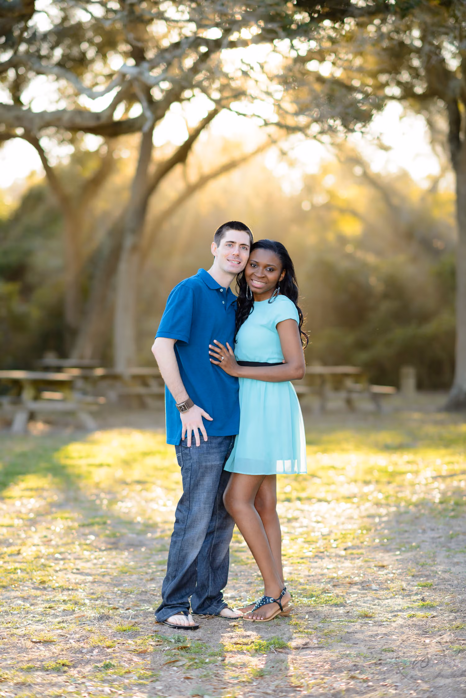 Couple posing together in soft winter light among oak trees and picnic tables at Myrtle Beach State Park