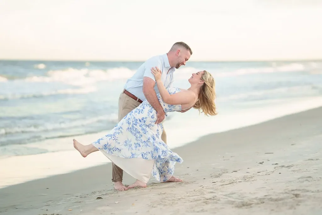 Dip by the edge of the ocean during Taylor's engagement session on the beach