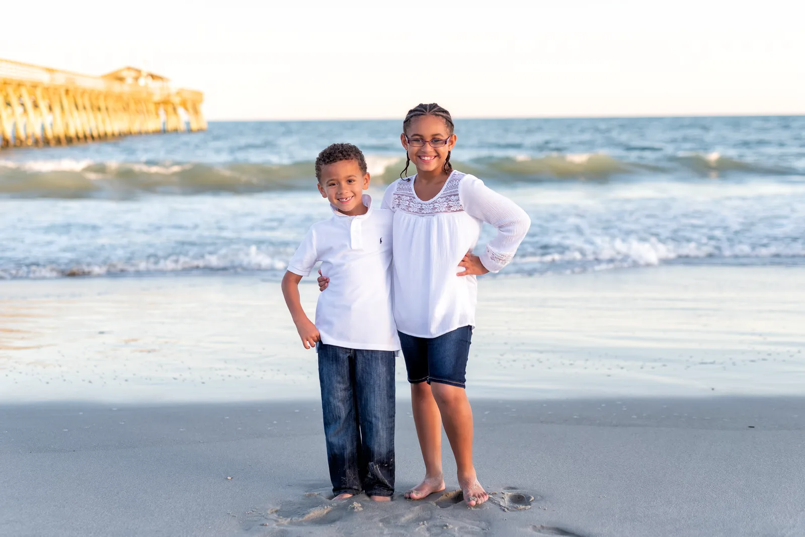 Brother and sister standing in front of the pier - Myrtle Beach State Park