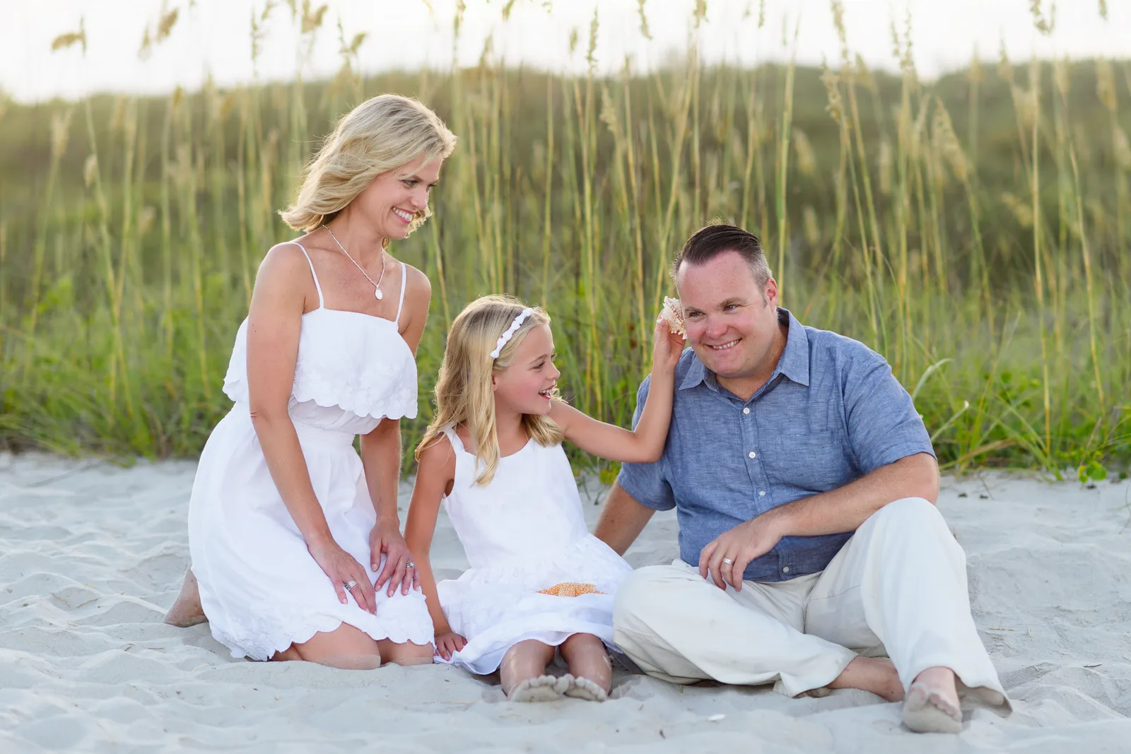 Little girl holding a shell to her dad's ear - Myrtle Beach State Park