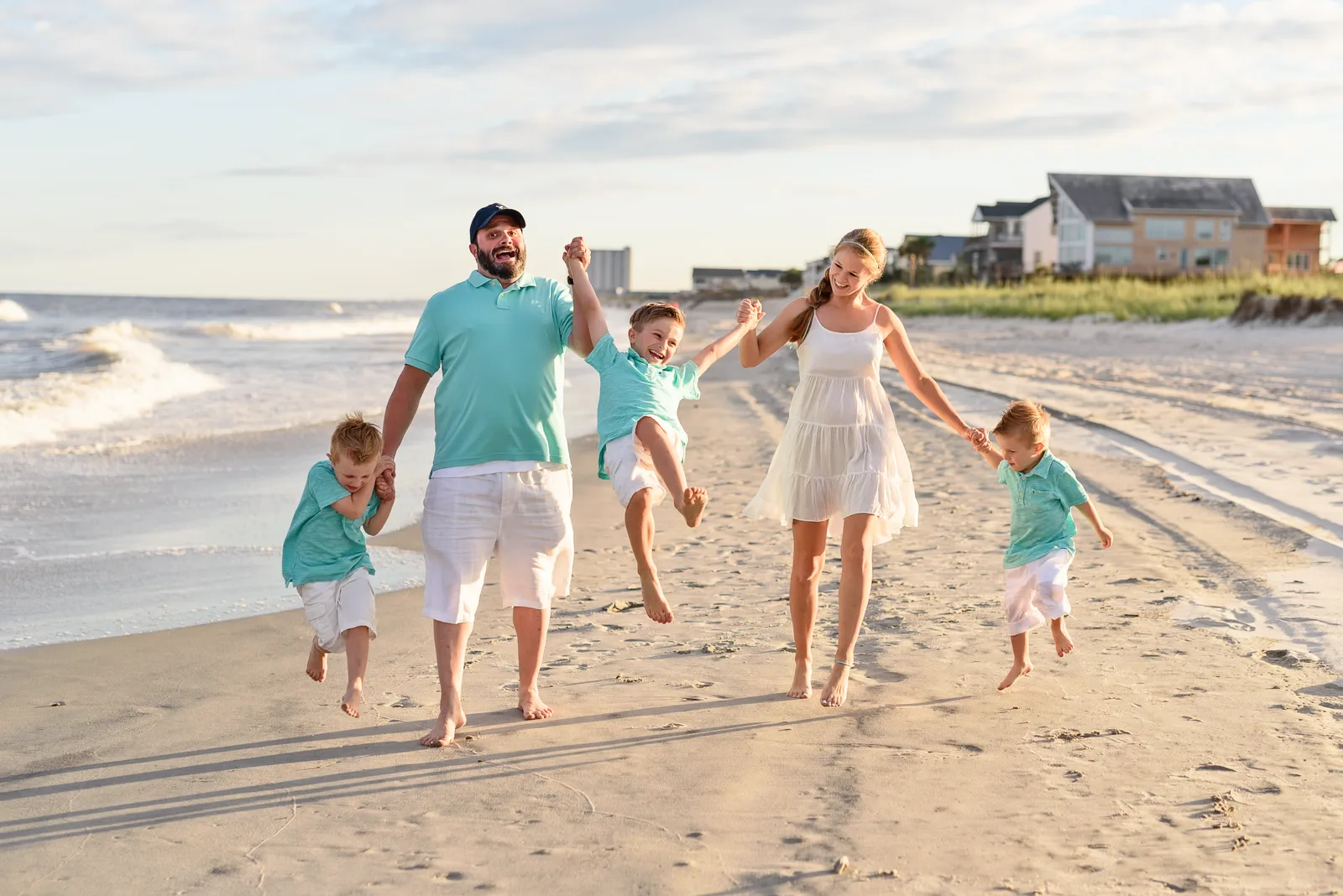 Family having fun swinging son in the air - Surfside Beach