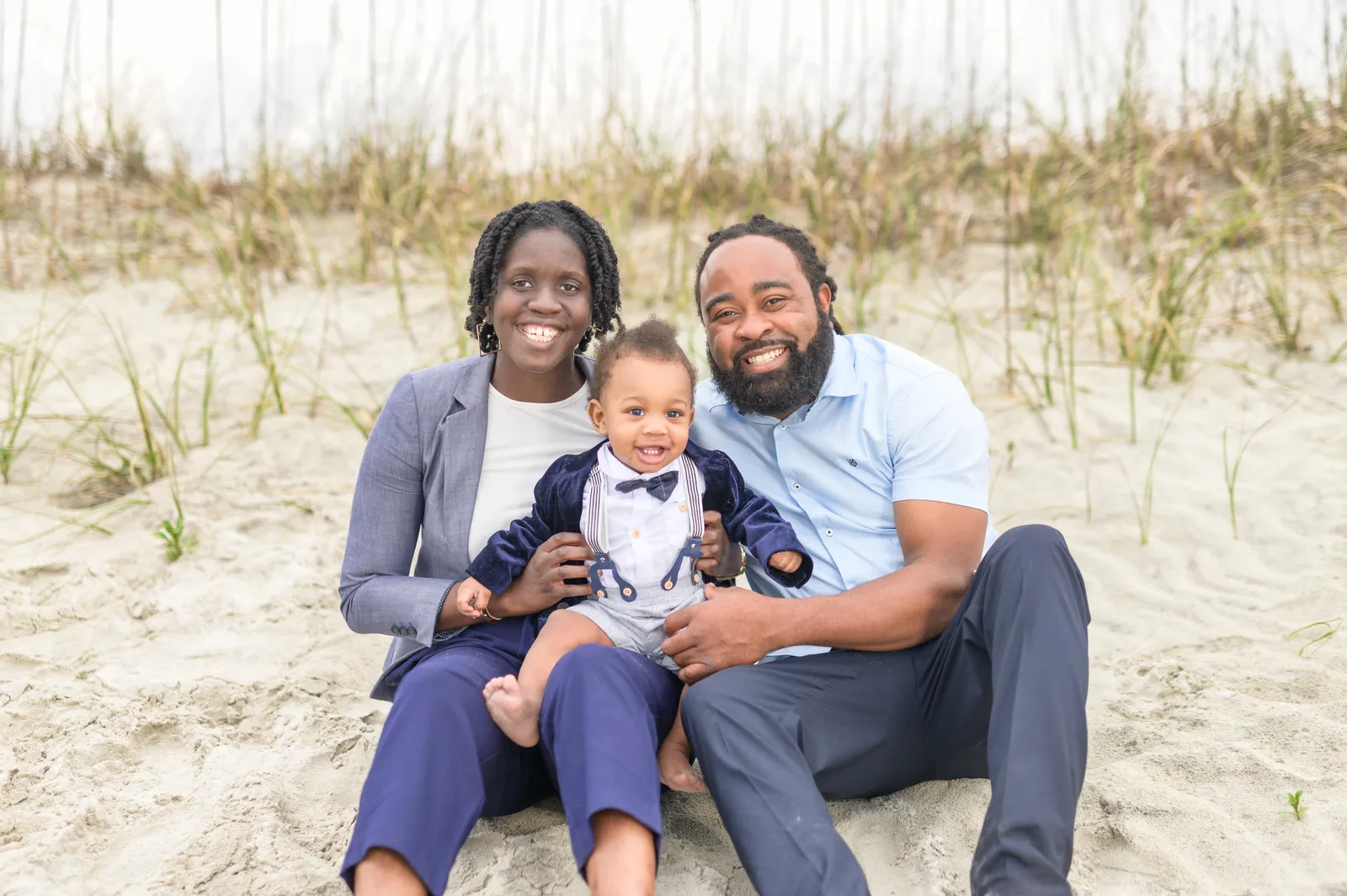 Mom and dad with a baby boy sitting by the dunes - Huntington Beach State Park
