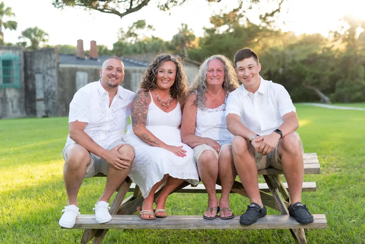 Family of 4 sitting on a picnic table in the sunset - Huntington Beach State Park