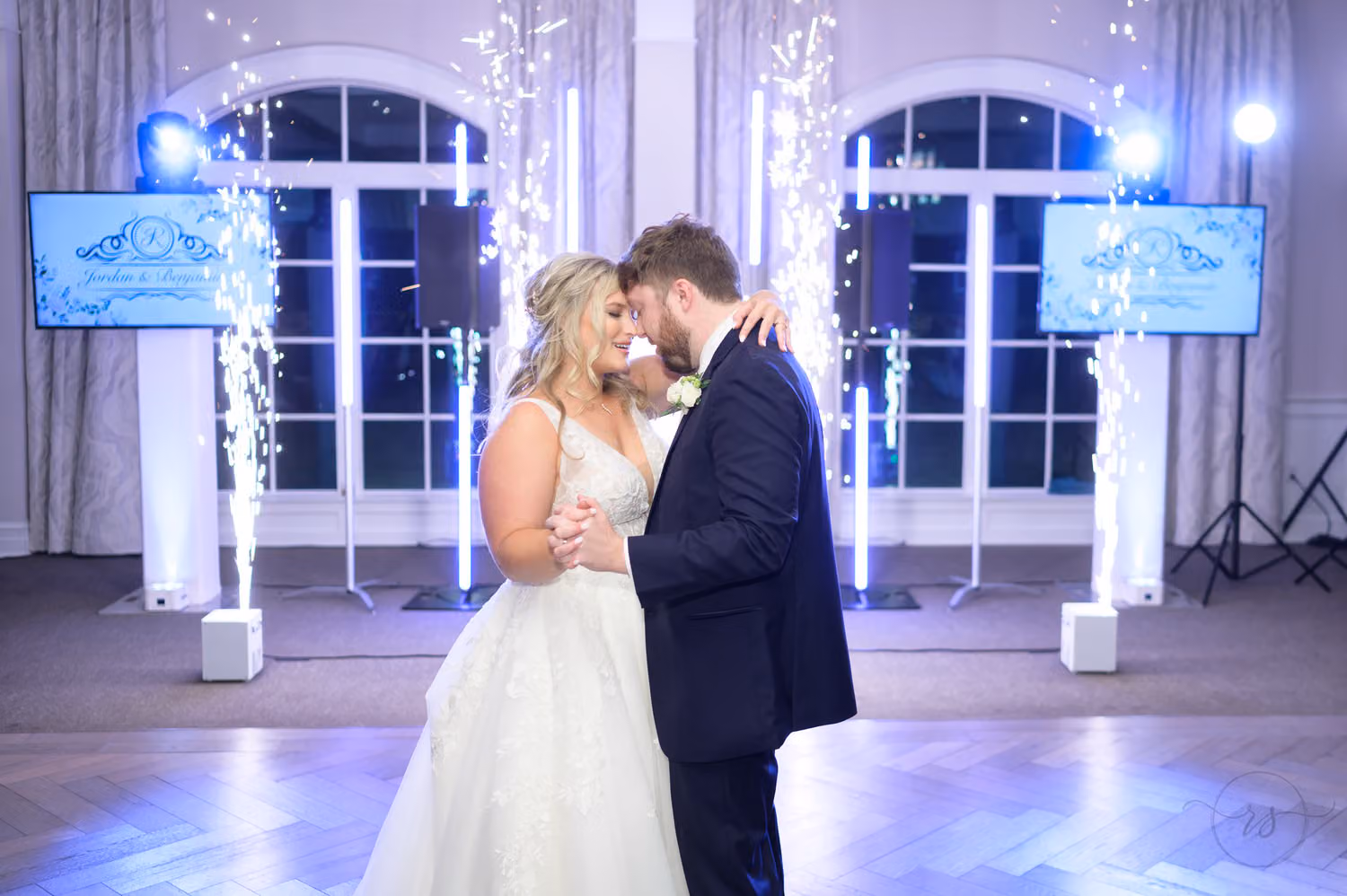 Bride and groom sharing their first dance between cold sparkler fountains and blue lights at 21 Main Events at North Beach
