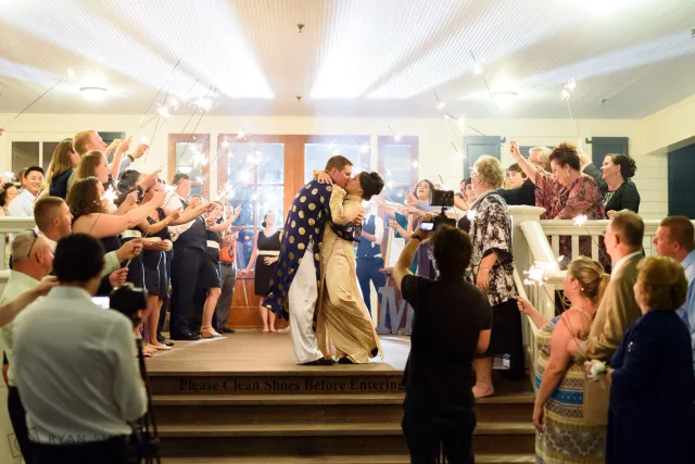 Groom dipping the bride for a kiss during the sparkler exit at the Dye Club at Barefoot Resort