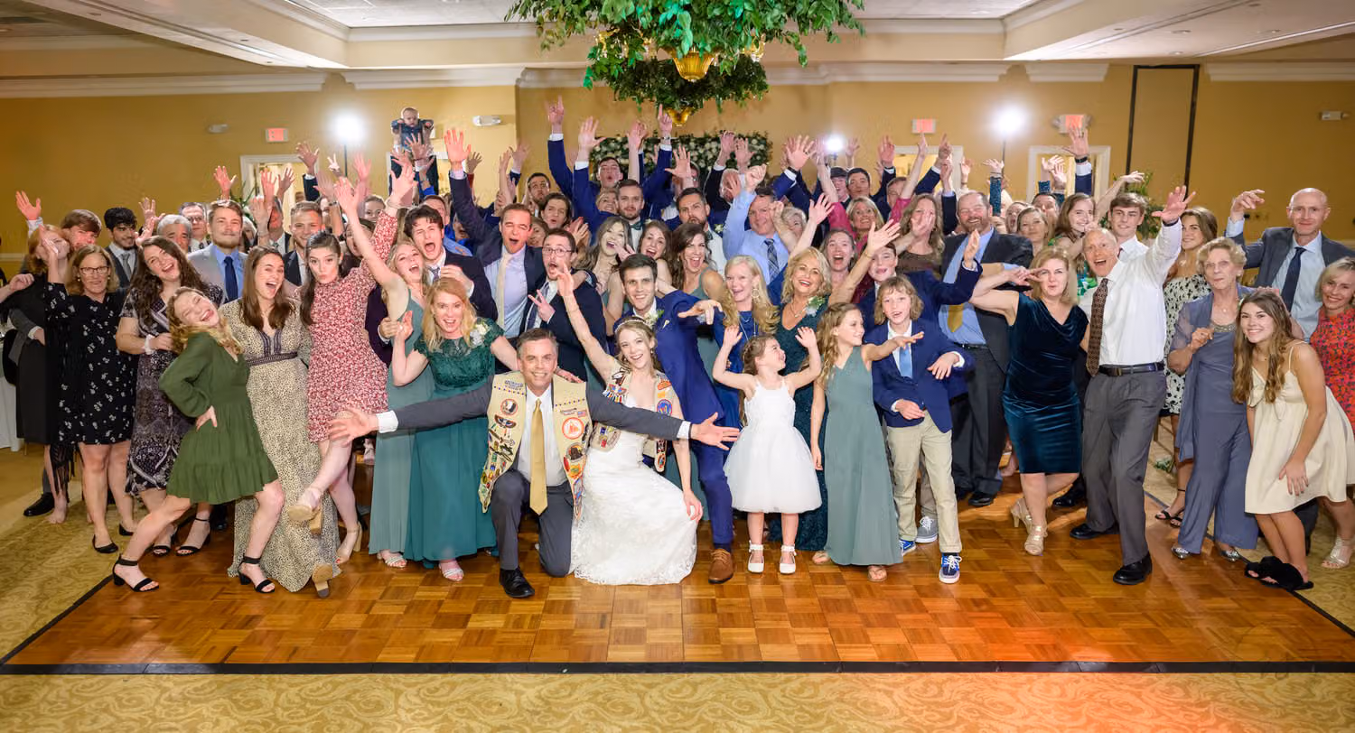 Wedding guests packed around the bride and groom with hands up on the dance floor at Pawleys Plantation Golf & Country Club