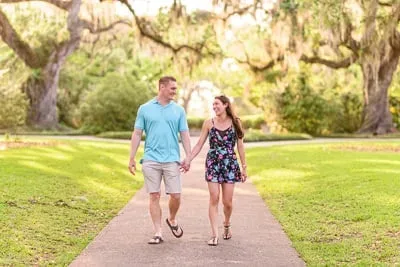 Just engaged couple walking through the oak trees - Brookgreen Gardens
