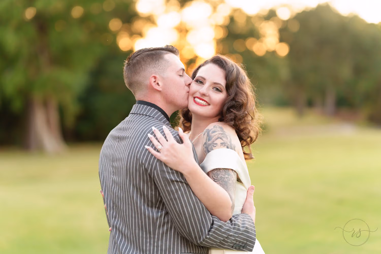 Groom kissing the bride on the cheek as she smiles with a hand on his chest at Litchfield Country Club