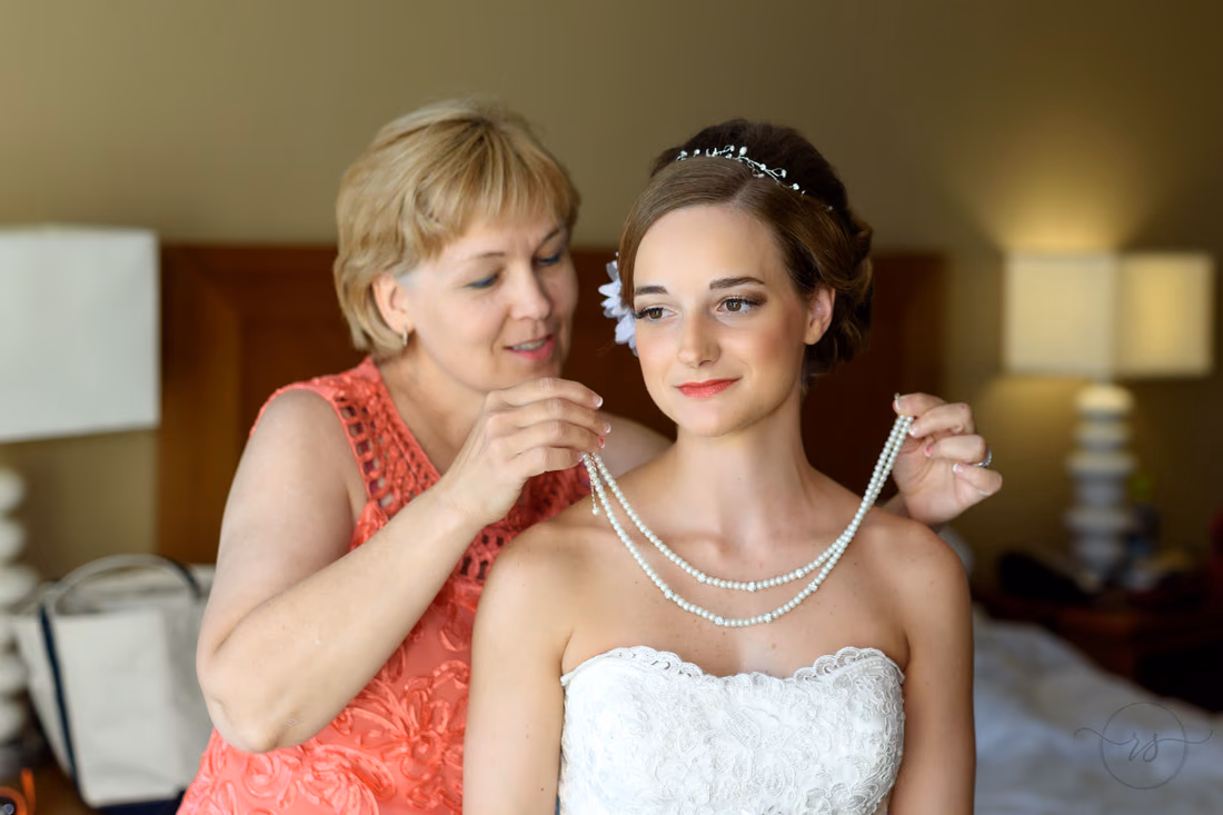 Bride's mom putting on her necklace before the ceremony - Hilton Myrtle Beach Resort at Kingston Resorts