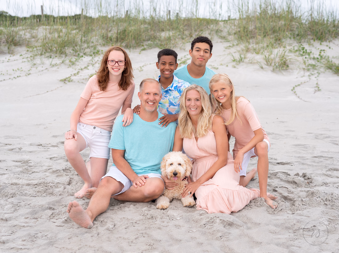 Cute family with their dog sitting in front of the dunes - Myrtle Beach State Park