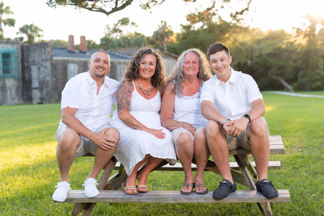 Family of 4 sitting on a picnic table in the sunset - Huntington Beach State Park