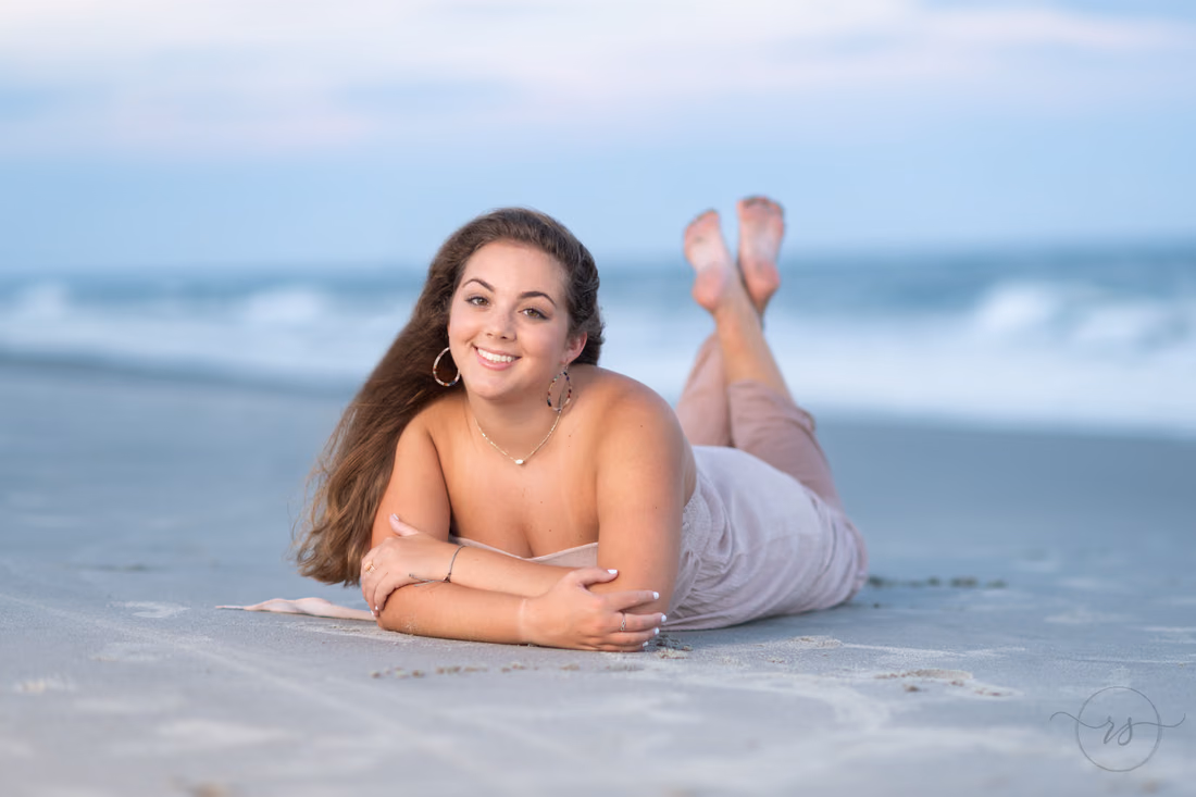 Senior girl portrait lying in the sand at Huntington Beach State Park