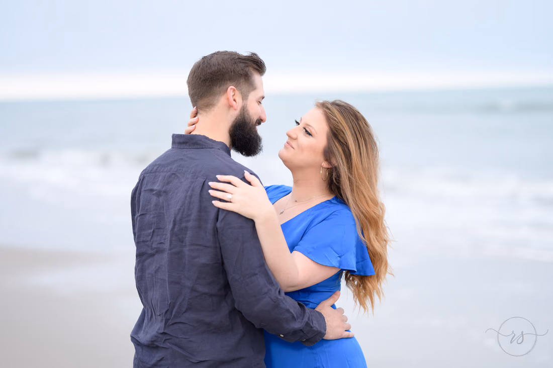She holds his face as they hug by the ocean - Myrtle Beach