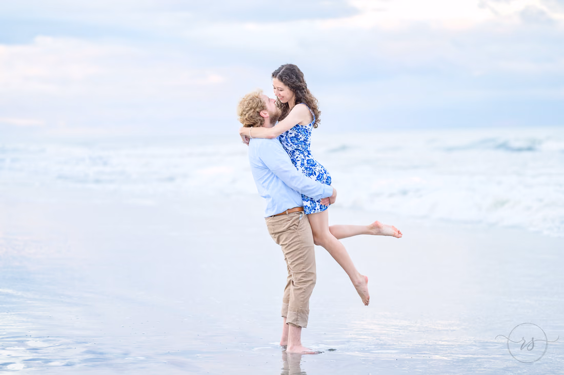 Lifting his fiancée into the air by the ocean - Huntington Beach State Park