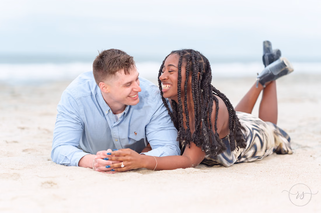 Couple lying in the sand laughing together - Huntington Beach State Park