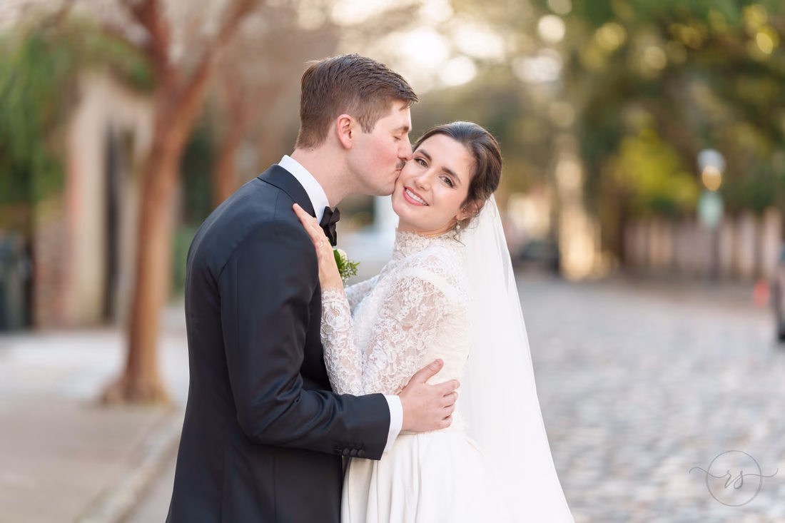 Kiss on the cheek with bride looking at the camera - Chalmers Street