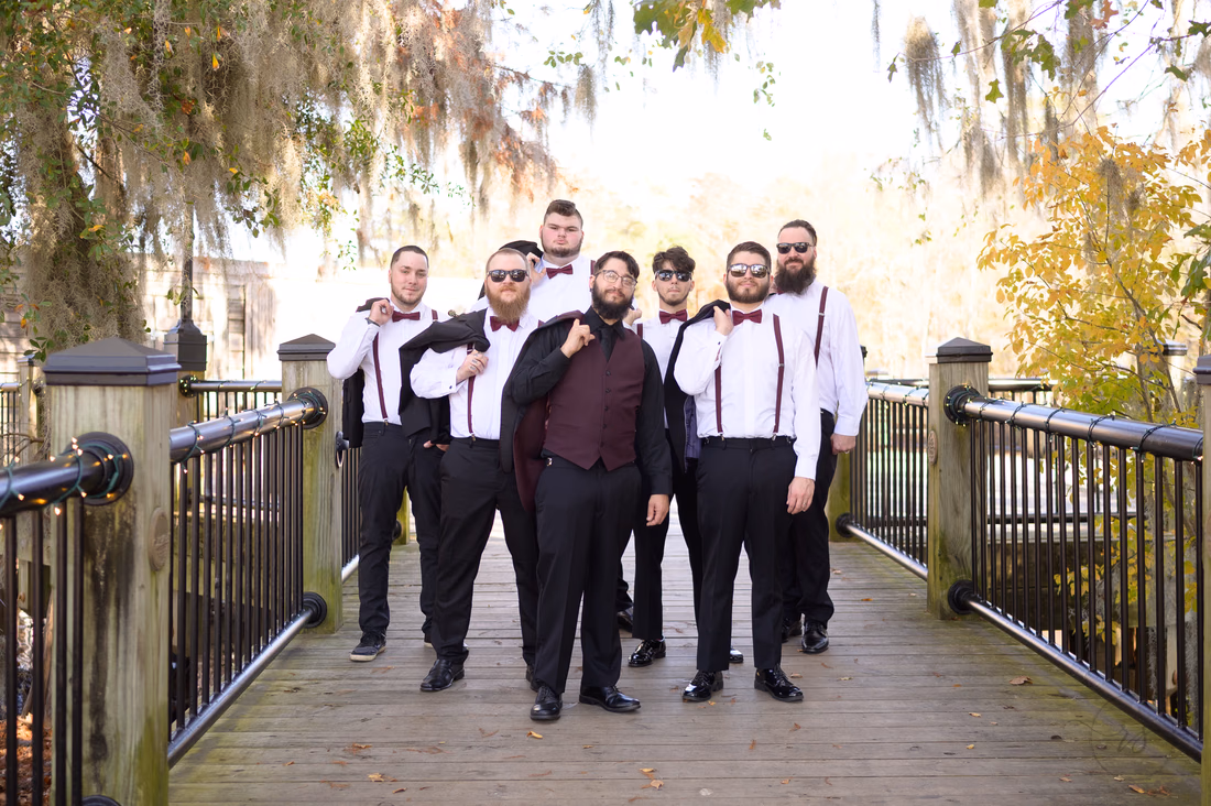 Groom and groomsmen posing on the boardwalk on the Conway Riverwalk