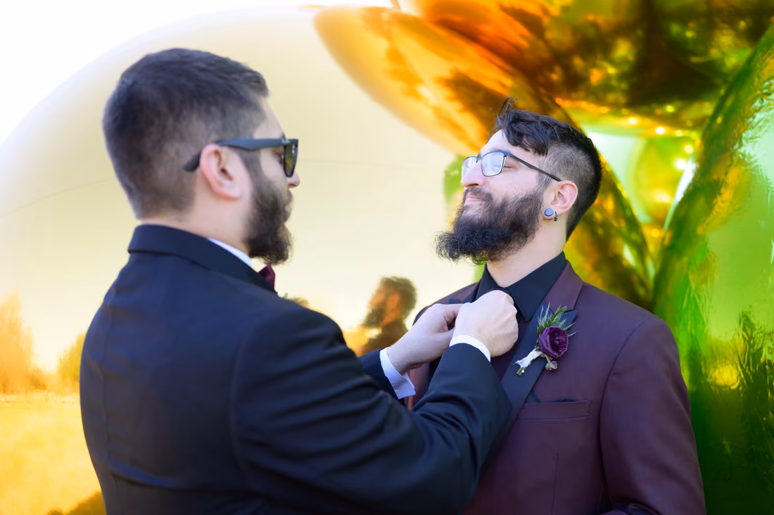 Groomsman adjusts the groom's tie before the wedding at The Cypress Inn in Conway