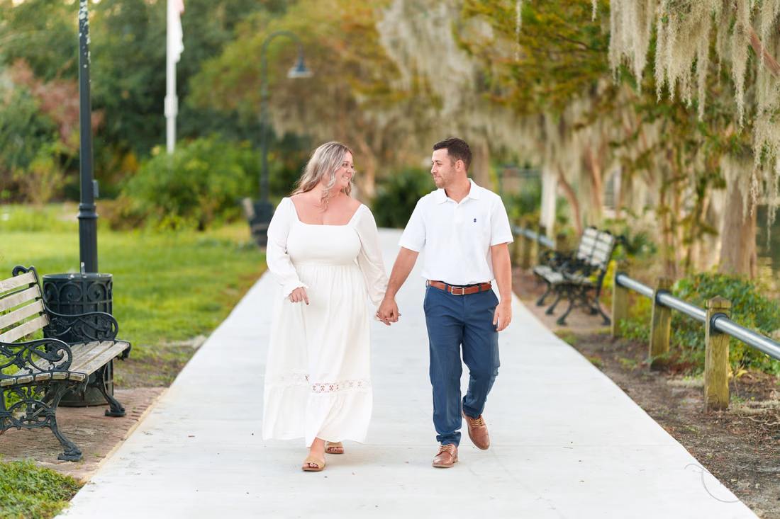 Holding hands walking under the trees - Conway Riverwalk
